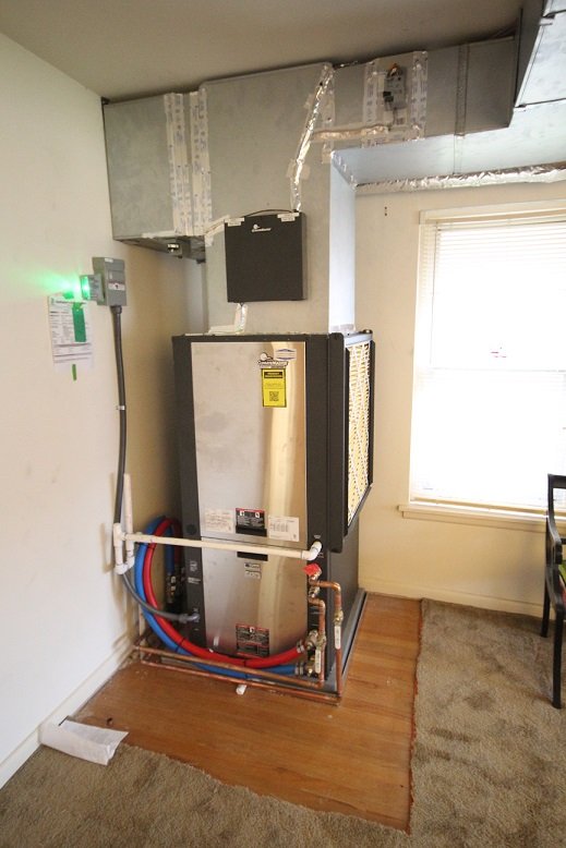 The finished indoor geothermal unit and hot water tank installed inside the home