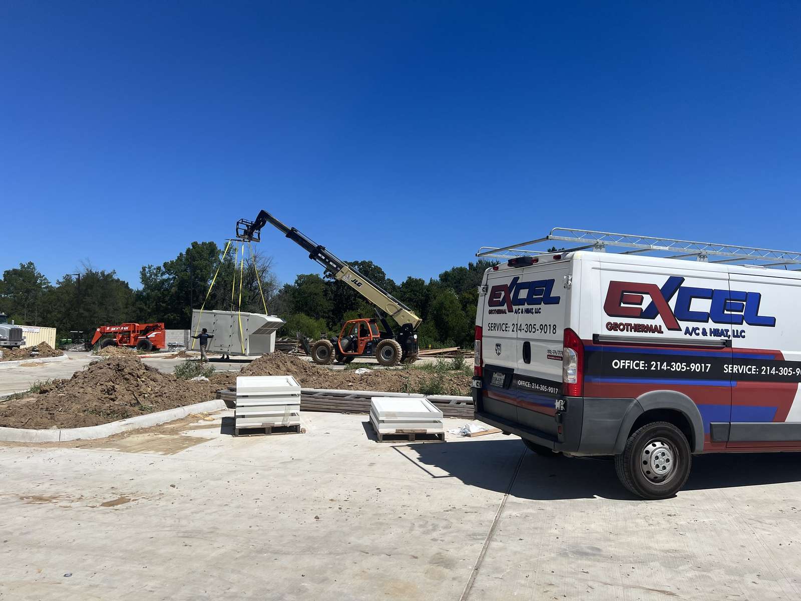 Excel Geothermal van on site as a crane lifts a heat-pump unit at Home2 Suites in Paris, Texas