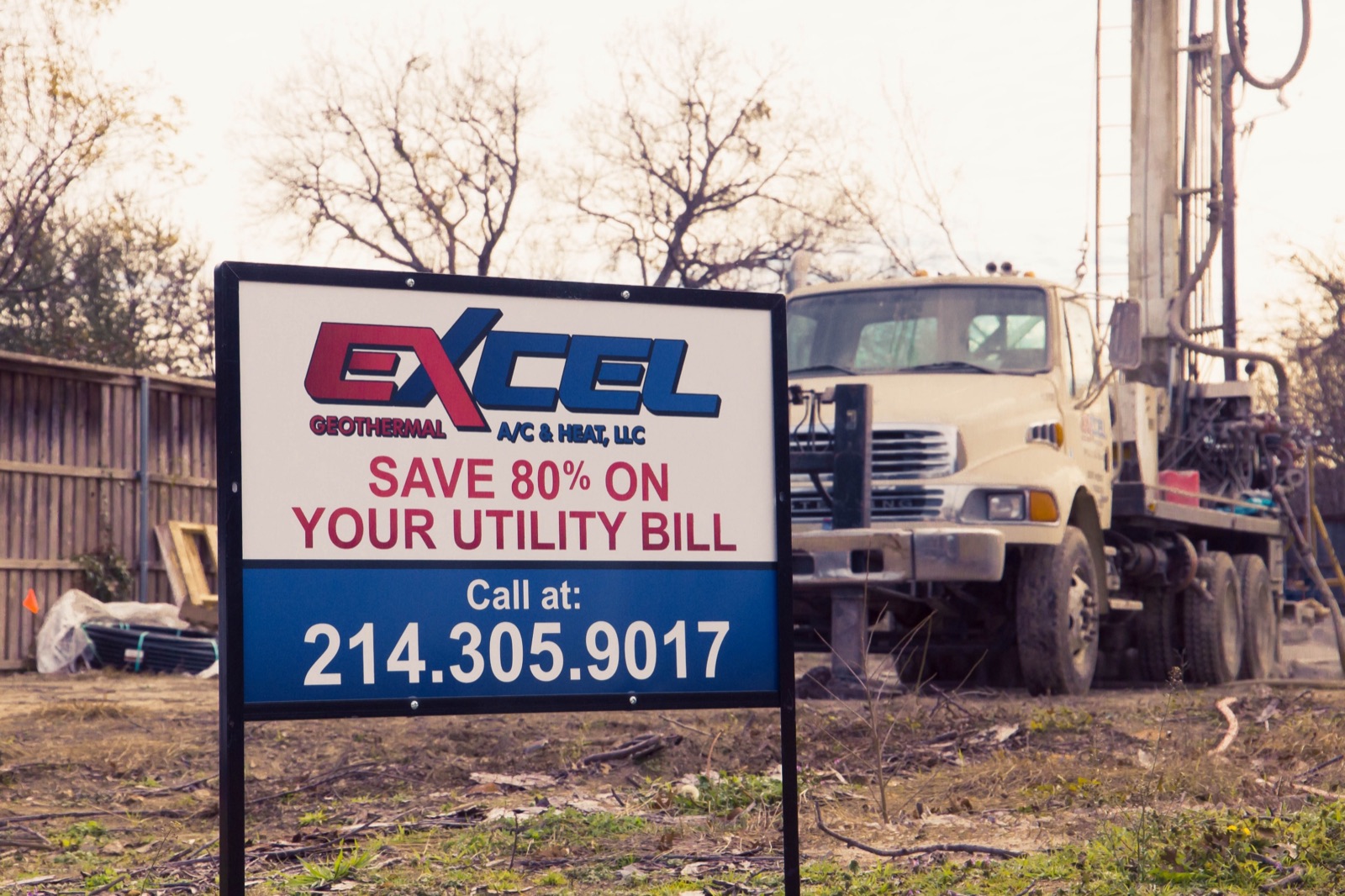 Excel Geothermal yard sign in front of a drilling rig at a Dallas-Fort Worth job site